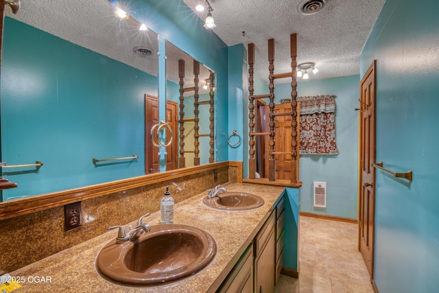 bathroom featuring heating unit, vanity, and a textured ceiling