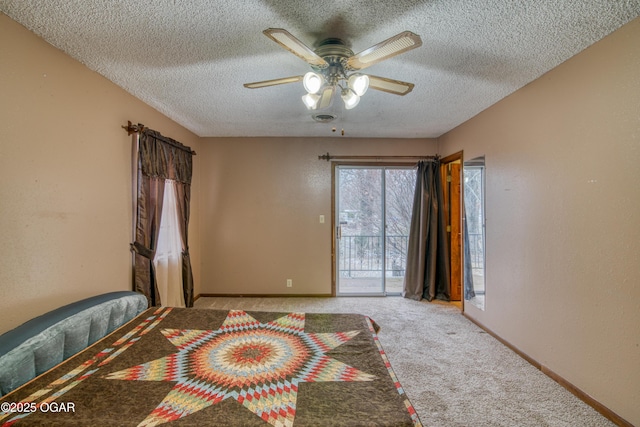 bedroom featuring a textured ceiling, access to outside, light colored carpet, and ceiling fan