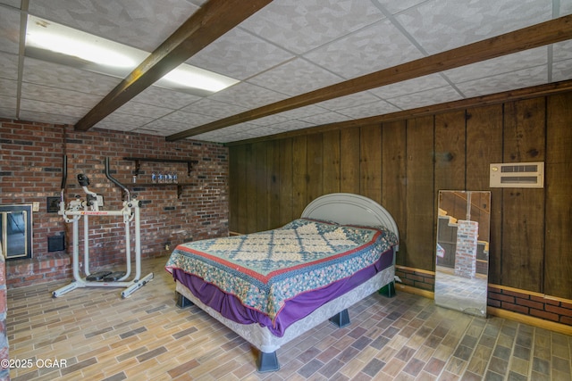 bedroom featuring wooden walls and a drop ceiling