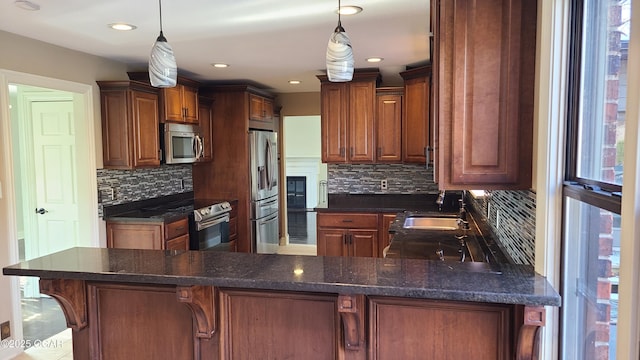 kitchen with pendant lighting, appliances with stainless steel finishes, a kitchen breakfast bar, and sink