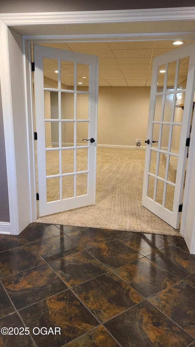 hallway with a drop ceiling and french doors