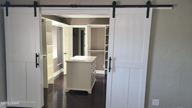 interior space with a barn door and dark hardwood / wood-style flooring