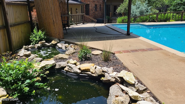 2007 E 47th St, Joplin, MO 64804 - view of swimming pool featuring a small pond and a wooden deck