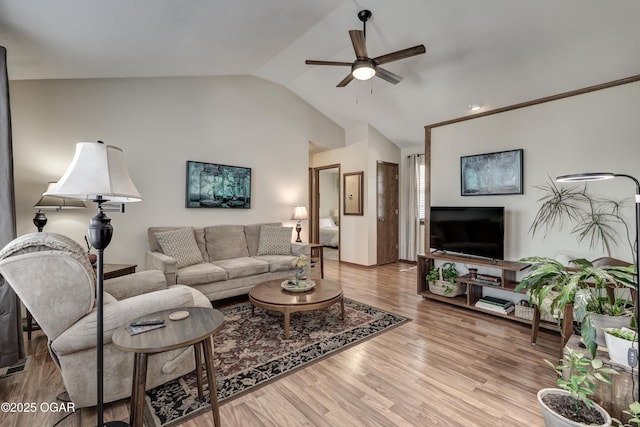 living room featuring ceiling fan, vaulted ceiling, and light hardwood / wood-style flooring