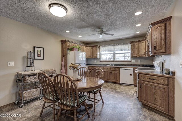 kitchen with ceiling fan, sink, white appliances, and a textured ceiling