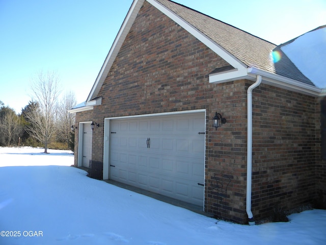 snow covered property featuring a garage