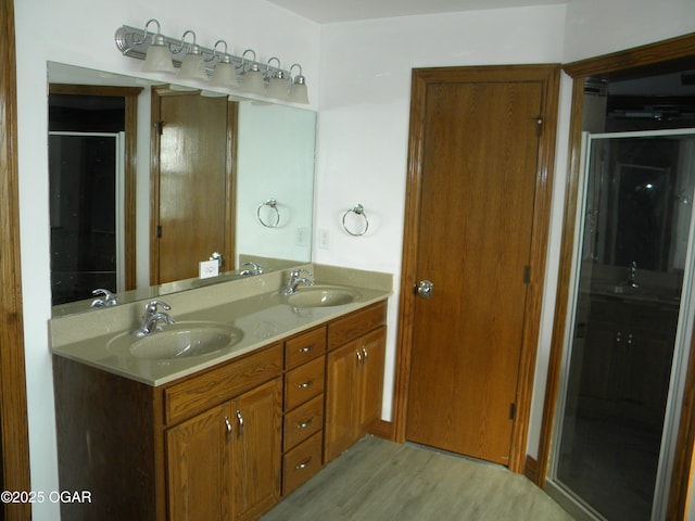 bathroom with an enclosed shower, vanity, and hardwood / wood-style flooring