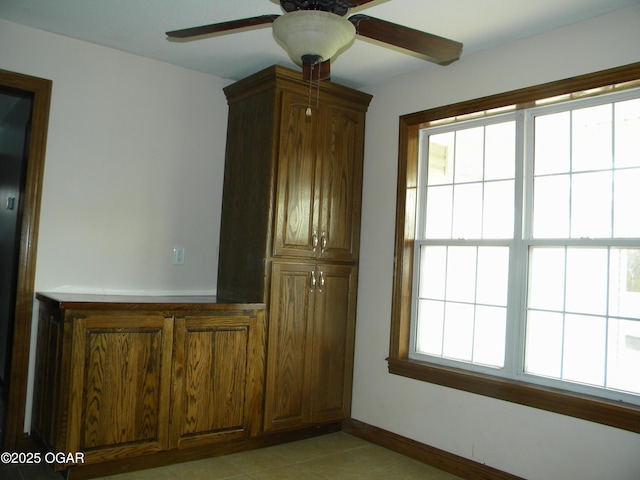 interior space with ceiling fan, light tile patterned flooring, and plenty of natural light