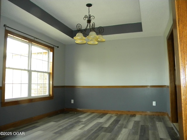 unfurnished room with a chandelier and hardwood / wood-style flooring