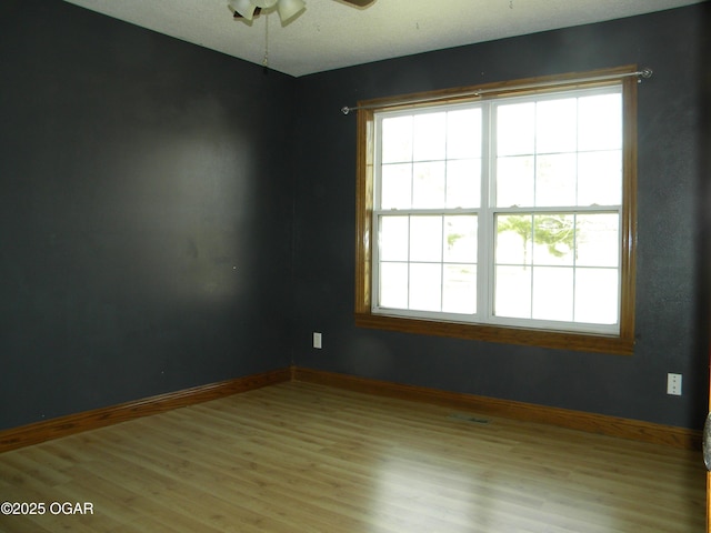 spare room featuring ceiling fan and light hardwood / wood-style floors