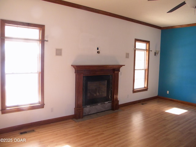 unfurnished living room with ceiling fan, light wood-type flooring, and ornamental molding