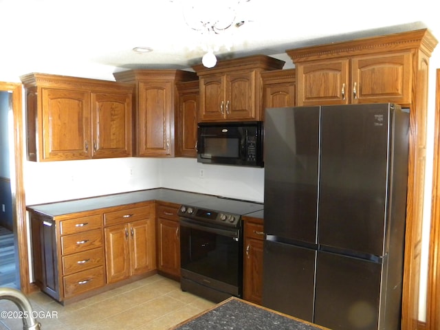 kitchen with light tile patterned floors, black appliances, and an inviting chandelier