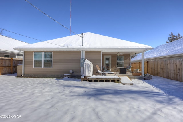 snow covered back of property featuring a porch