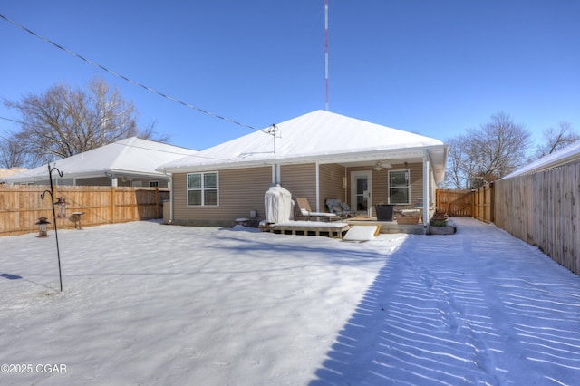 snow covered rear of property featuring ceiling fan