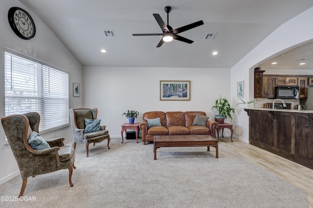 living room with ceiling fan and vaulted ceiling