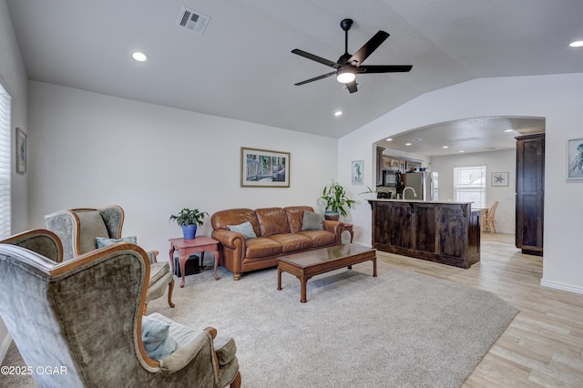 living room with vaulted ceiling, light wood-type flooring, and ceiling fan