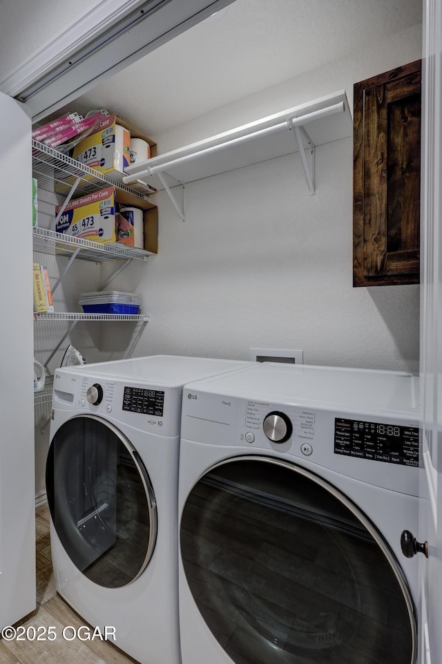 laundry room featuring wood-type flooring and washer and clothes dryer