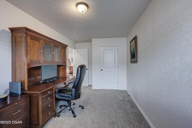 office with light colored carpet and a textured ceiling