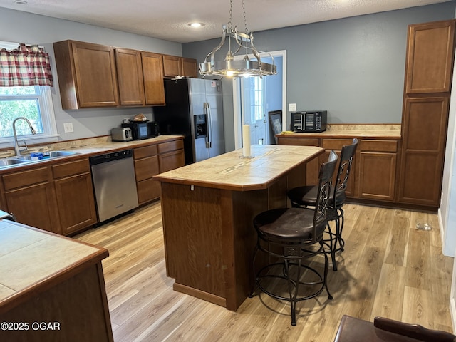 1019 Hawthorne St, Carthage, MO 64836 - kitchen featuring stainless steel appliances, tile countertops, light wood-type flooring, and a center island