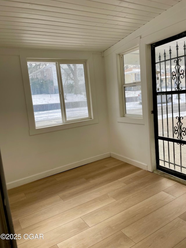 interior space featuring wood ceiling, plenty of natural light, light wood-style flooring, and baseboards