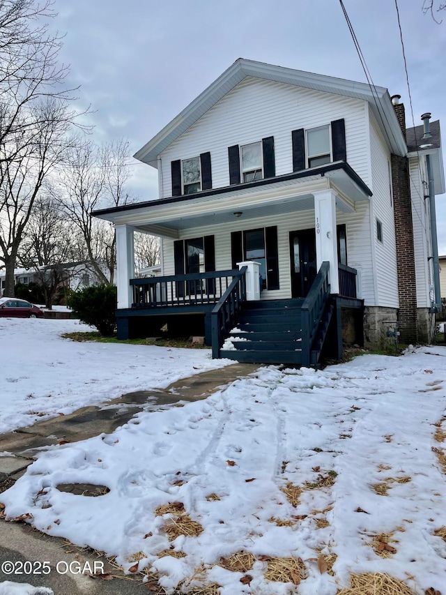 view of front of house with a chimney and a porch