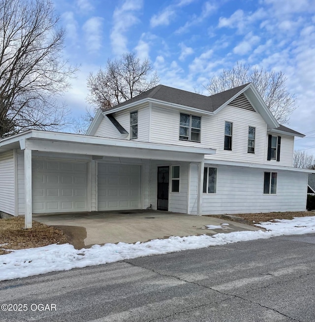 traditional-style home featuring driveway, roof with shingles, and an attached garage