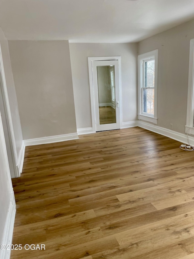 empty room with light wood-style floors and baseboards