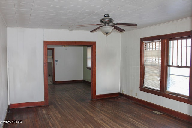 empty room with dark wood-type flooring and ceiling fan