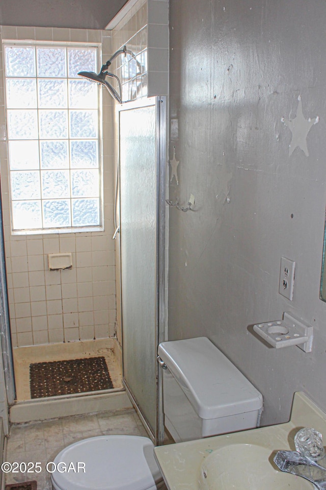 bathroom featuring toilet, a tile shower, and vanity