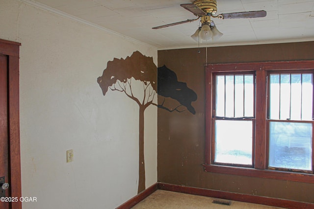 carpeted spare room featuring ornamental molding and ceiling fan