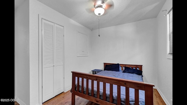 bedroom with a textured ceiling, ceiling fan, light hardwood / wood-style flooring, and a closet