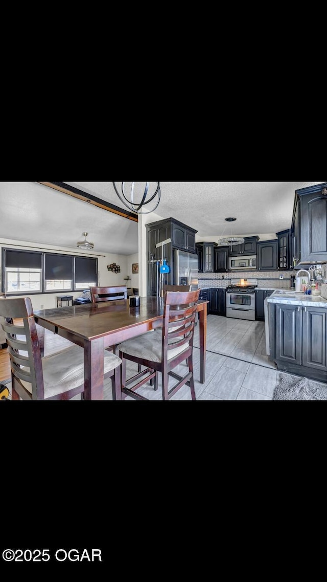 tiled dining space featuring ceiling fan and a textured ceiling