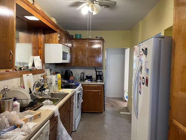 kitchen with ceiling fan, sink, white appliances, decorative backsplash, and dark brown cabinets