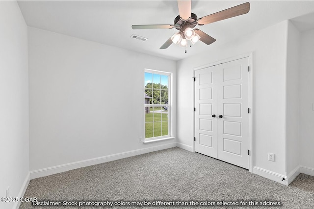 unfurnished bedroom with carpet, a closet, and ceiling fan