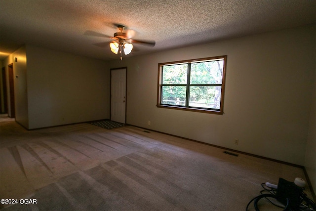 empty room with ceiling fan, a textured ceiling, and carpet flooring