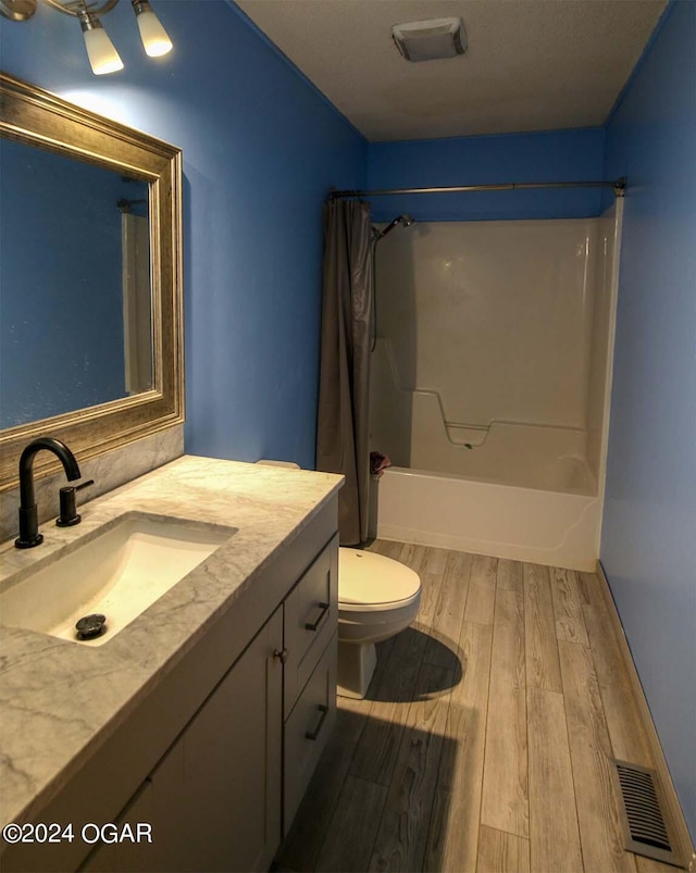 full bathroom featuring toilet, hardwood / wood-style flooring, shower / tub combo, and vanity