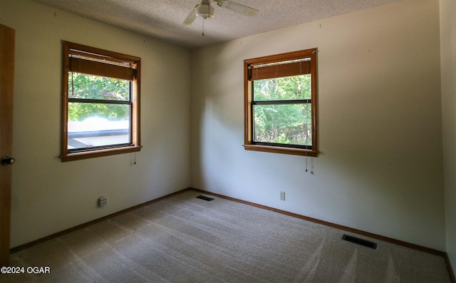 carpeted empty room with a textured ceiling and ceiling fan