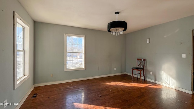 unfurnished room featuring a healthy amount of sunlight and dark hardwood / wood-style floors