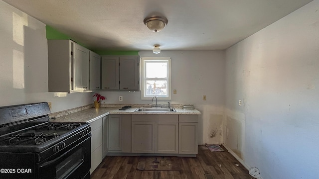 kitchen with sink, gray cabinetry, dark hardwood / wood-style flooring, and black gas range oven