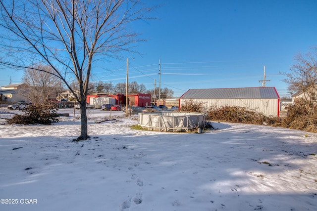 yard covered in snow with a covered pool