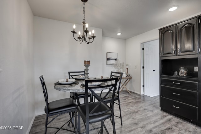 dining area with a notable chandelier and light hardwood / wood-style flooring