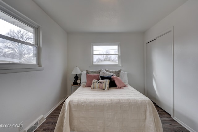 bedroom with dark wood-type flooring and a closet