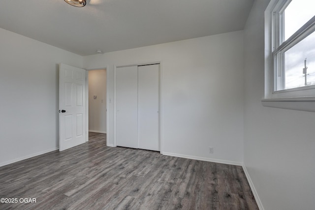 unfurnished bedroom featuring wood-type flooring and a closet