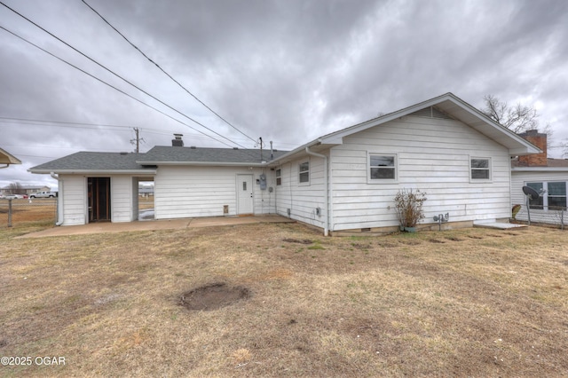 rear view of property featuring a patio area and a lawn