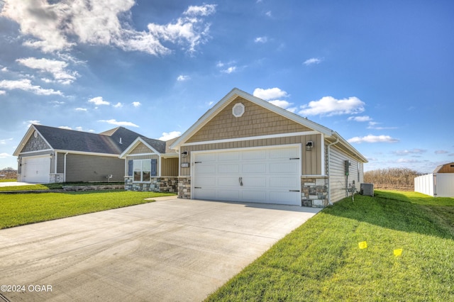 view of front of home featuring cooling unit, a garage, and a front yard