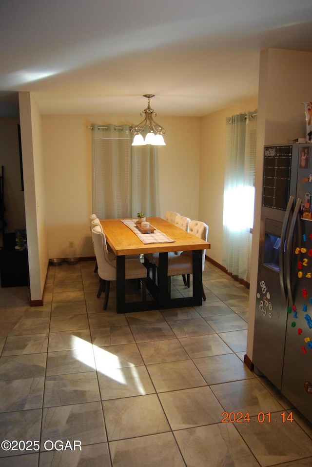 dining area with an inviting chandelier and tile patterned floors