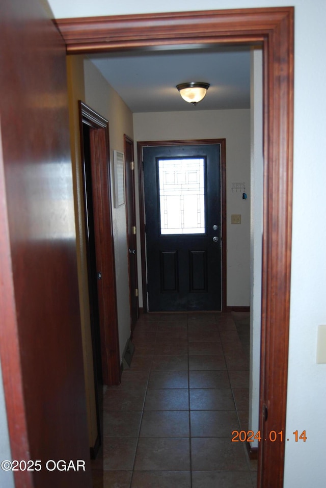 doorway with dark tile patterned flooring