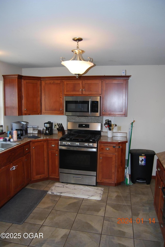 kitchen with sink, stainless steel appliances, and tile patterned flooring