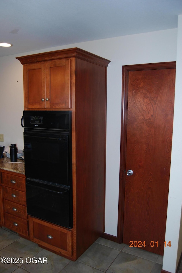 kitchen featuring double oven and light tile patterned floors