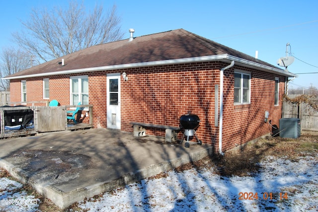 snow covered house featuring a patio and central air condition unit